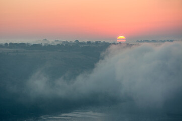 Fototapeta na wymiar sunset sunrise in mist with lake and hills