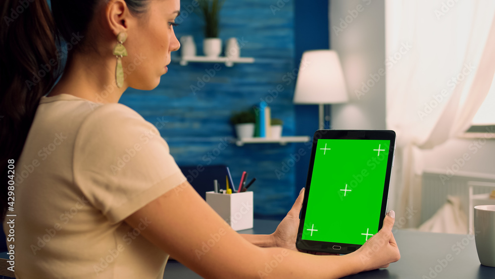 Poster business woman having online videocall with treamates uses tablet computer with mock up green screen