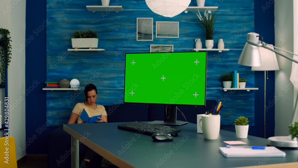 Poster freelancer working on powerful computer with mock up green screen chroma key display sitting on desk