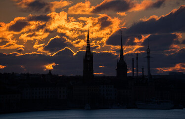 Morning skyline of the old town Gamla Stan at spring equinox at sunrise. Orange clouds over the Stockholm archipelago