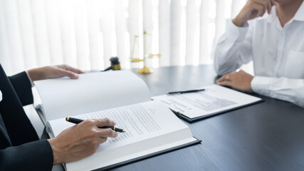 law,libra scale and hammer on the table, 2 lawyers are discussing about contract paper, law matters determination