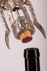 Red wine bottle, cork stopper and an italian prestigious corkscrew on a white background