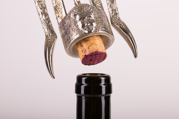 Red wine bottle, cork stopper and an italian prestigious corkscrew on a white background