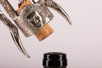 Red wine bottle, cork stopper and an italian prestigious corkscrew on a white background