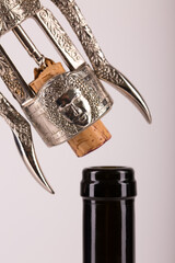 Red wine bottle, cork stopper and an italian prestigious corkscrew on a white background