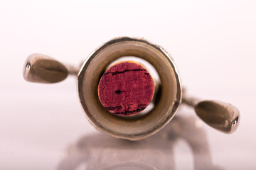 Red wine bottle, cork stopper and an italian prestigious corkscrew on a white background