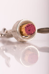 Red wine bottle, cork stopper and an italian prestigious corkscrew on a white background