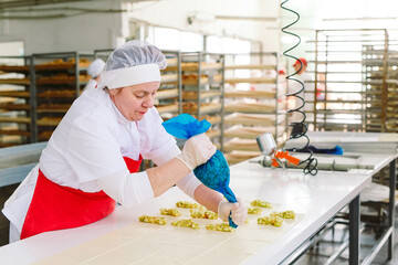 Workers of the confectionery factory prepare desserts with filling.