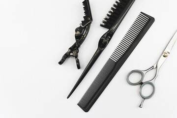 hairdressing accessories on a white table like tweezers, comb, scissors