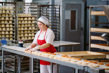 Conveyor belt in a bakery with newly baked buns.