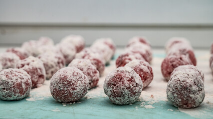 Meat balls covered with flour lie on the surface. The cooking process. Tasty food. Close-up.