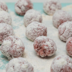 Meat balls covered with flour lie on the surface. The cooking process. Tasty food. Close-up.