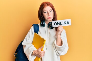 Young red head girl wearing backpack holding online banner depressed and worry for distress, crying angry and afraid. sad expression.