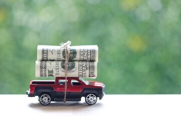 Miniature car and banknotes on nature green background, Saving money for car, Finance and car loan,...