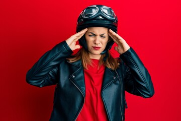 Hispanic young woman wearing motorcycle helmet suffering from headache desperate and stressed because pain and migraine. hands on head.