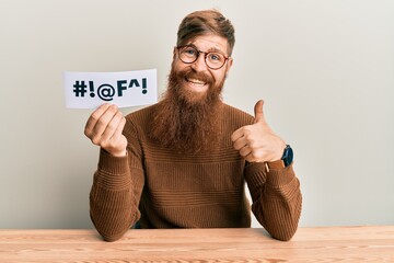 Young irish redhead man holding paper with insult message sititng on the table smiling happy and...