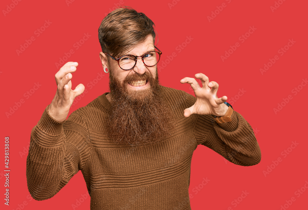 Poster young irish redhead man wearing casual clothes and glasses shouting frustrated with rage, hands tryi