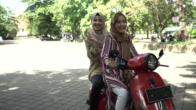 portrait of happy muslim girls riding scooter enjoy summer vacation with friends