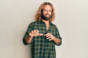 Handsome man with beard and long hair wearing casual clothes disgusted expression, displeased and...