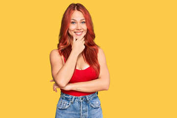 Young redhead woman wearing casual clothes looking confident at the camera smiling with crossed arms and hand raised on chin. thinking positive.