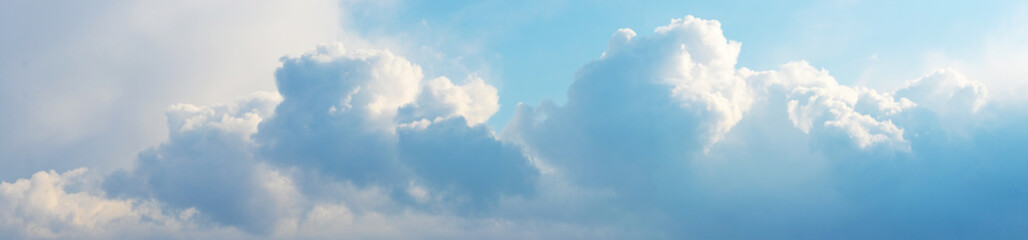 Blue and white clouds in the sky in bright sunlight