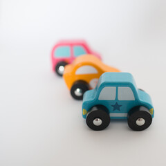 Three colorful toy cars in a row with white background