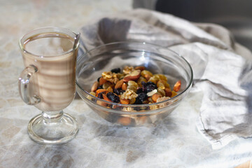 Morning natural breakfast with a cup of coffee with milk and nuts with raisins
