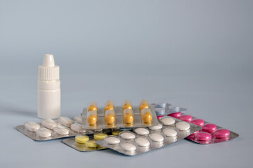 Different medicines- tablets and pills in blister pack, medications drugs and white plastic medical...