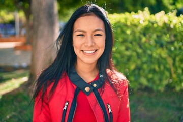 Fototapeta premium Young latin woman smiling happy walking at the park.