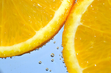 orange in sparkling water with bubbles. macro.