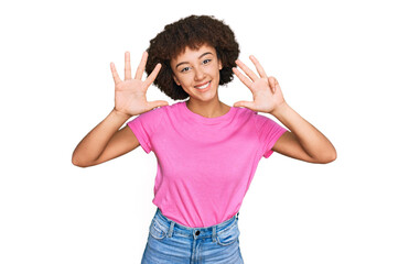 Obraz na płótnie Canvas Young hispanic girl wearing casual clothes showing and pointing up with fingers number nine while smiling confident and happy.