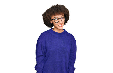 Fototapeta na wymiar Young hispanic girl wearing casual winter sweater and glasses looking away to side with smile on face, natural expression. laughing confident.
