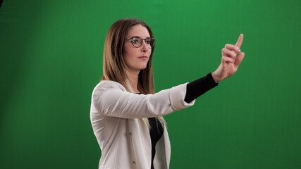 Young woman taps on a large imaginary touchscreen - studio photography