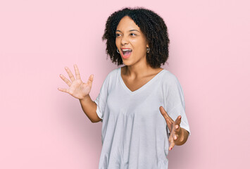 Young african american girl wearing casual clothes crazy and mad shouting and yelling with...