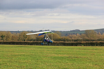 Ultralight airplane landing on a grass strip	