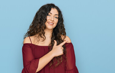 Young hispanic girl wearing casual clothes cheerful with a smile of face pointing with hand and finger up to the side with happy and natural expression on face