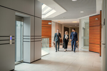 Modern business colleagues walking in corridor