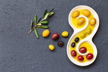 Olive oil and olives image on black insulated table. Generally, olive oil is used in salads, stuffed peppers and cooking.