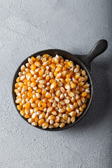 Corn seeds in the bowl on gray background.