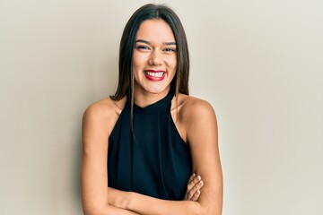 Young hispanic girl wearing casual style with sleeveless shirt happy face smiling with crossed arms...