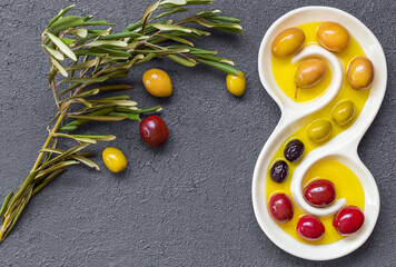 Olive oil and olives image on black insulated table. Generally, olive oil is used in salads, stuffed peppers and cooking.