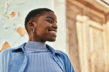 Young african american woman smiling happy standing at the city.