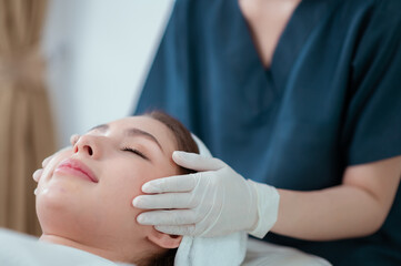 Fototapeta na wymiar Woman under professional facial massage in beauty spa