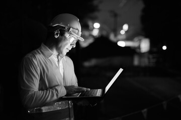 Handsome Persian man construction worker at the construction site at night
