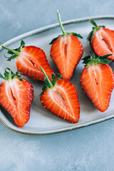 Fresh juicy strawberry on a plate in the kitchen table, top view.