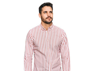 Fototapeta premium Young hispanic man wearing business shirt smiling looking to the side and staring away thinking.