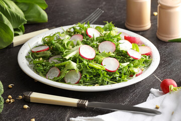 Plate of tasty salad with fresh vegetables on dark background