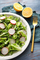 Plate of tasty salad with fresh vegetables on color wooden background