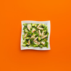 Plate of tasty salad with fresh vegetables and chicken on color background