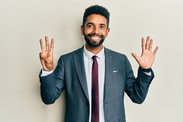 Handsome hispanic man with beard wearing business suit and tie showing and pointing up with fingers number eight while smiling confident and happy.